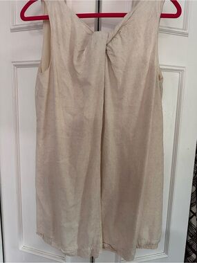 Sleeveless Cream Twist-front Tunic with slit in front and zippered v-neck back